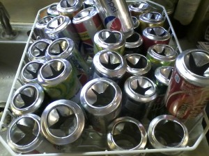 Collected cans with lids removed and slits cut into bottoms